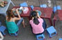 HANOI. Giovani donne mangiano sui marciapiedi sedute su sgabelli