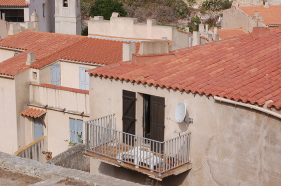 BONIFACIO - Percorriamo a piedi Avenue Charles de Gaulle per raggiungere la cittadella e osserviamo il porto più in basso e i tetti delle abitazioni a lato della strada