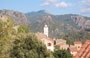 ENTROTERRA DI PORTO. Il campanile della chiesa di Ota, svetta tra le alte montagne circostanti quasi al centro del villaggio