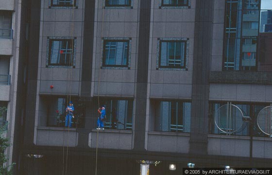 TOKYO GINZA - Verso i Giardini di Palazzo Hama: lavavetri all'opera sulla facciata di questo edificio ben equipaggiati con funi e dispositivi di protezione individuali