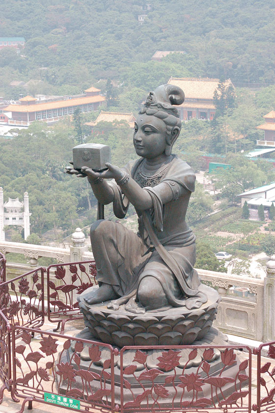 ISOLA DI LANTAU  - Sullo sfondo della statua in bronzo di bodhisattva si intravedono gli edifici ed il tempio del Monastero di Po Lin tra il verde della collina