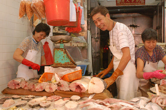 WAN CHAI - Il pescivendolo posa divertito per la nostra foto