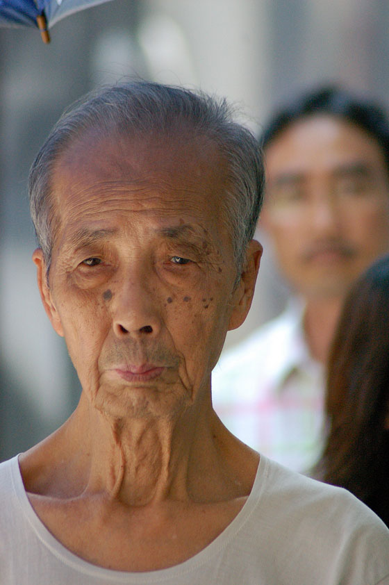 WAN CHAI - Il volto segnato dal tempo e l'espressione curiosa di questo anziano cinese ci colpiscono