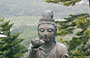 MONASTERO DI PO LIN. Il volto sereno di una statua in bronzo di bodhisattva mentre offre un fiore al Buddha