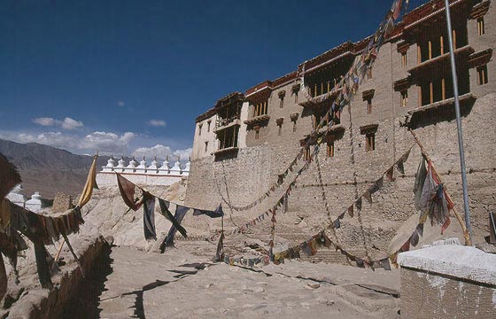 LADAKH - Shey Gompa attraversato di bandiere colorate con preghiere buddhiste e sullo sfondo i caratteristici stupa della regione