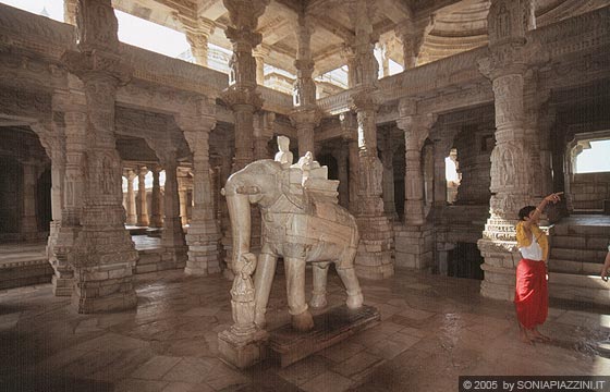 RANAKPUR - Chaumukha Temple - a lato un giovane giainista intento a guidare i turisti alla scoperta del tempio e al centro la statua di un elefante