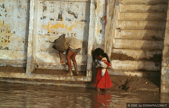 VARANASI - Dalla nostra barca avvistiamo questi bambini che scendono ai ghat sommersi dalle acque melmose del Gange
