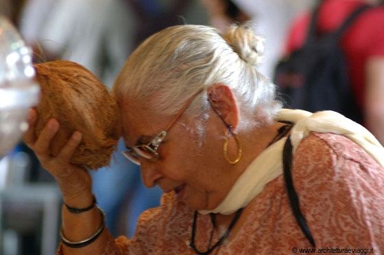 SRI VEERAMAKALIAMMAN TEMPLE - Questa anziana induista prega battendo sulla sua fronte una noce di cocco, simbolo della distruzione dell'ego