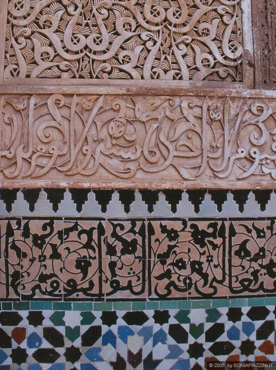 MARRAKESH - Medersa di Ali ben Youssef: decorazioni a stucco con iscrizione coranica in rilievo poggiate su una base di mattonelle zellij