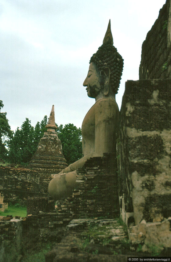 SUKHOTHAI - Wat Mahathat - Profilo di un Buddha che tocca la terra addossato ad un chedi a più strati in mattoni rossi