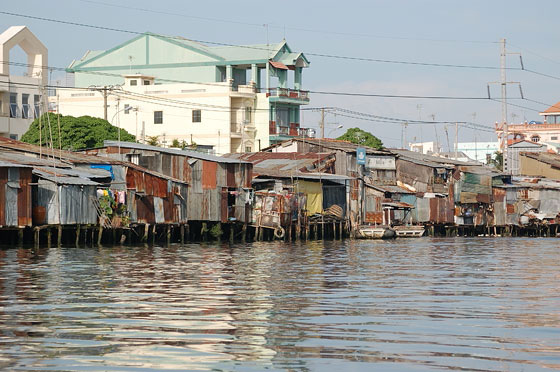 DINTORNI DI SAIGON - Appena partiti ci colpiscono le numerose palafitte in lamiera in riva al fiume che contrastano con gli edifici sul retro