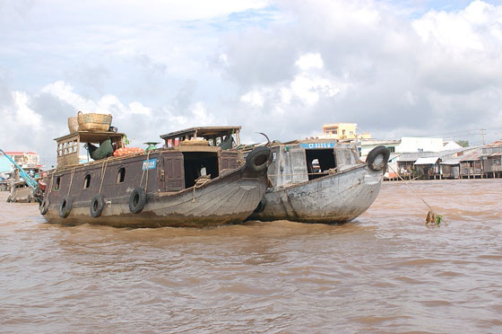 DELTA DEL MEKONG - Sembra una natura morta: due barche, l'acqua melmosa e rossa, il cielo assolato e al contempo denso di nubi