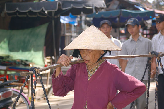 HOI AN - Un'anziana signora con in spalla il suo bilanciere