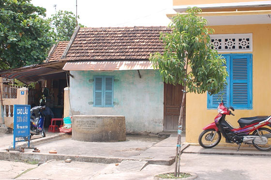 HOI AN - Una tipica abitazione ed un pozzo; vicino la scritta indica un locale che prepara il Cao Lau