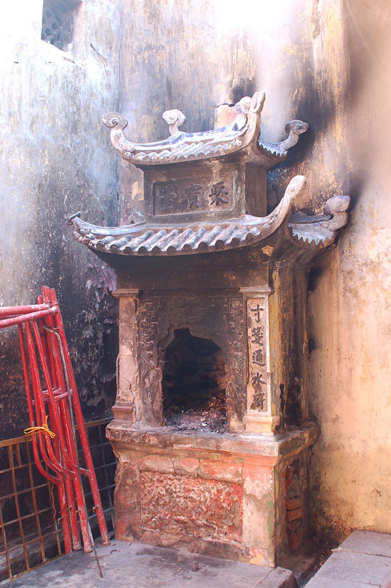 HANOI - Tempio Bach Ma: in un camino d'angolo vengono bruciate offerte votive fatte di carta 