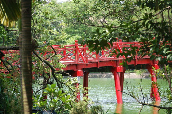 HANOI - Tra la vegetazione intorno all'isoletta del tempio, si intravede il ponte di legno dipinto di rosso, The Huc (Sole Nascente)