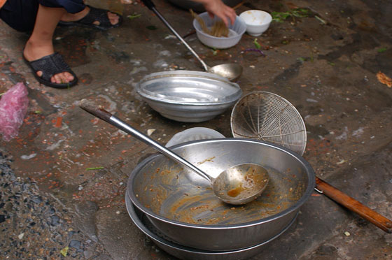HANOI - Stoviglie unte sul marciapiede di fronte ad una taverna