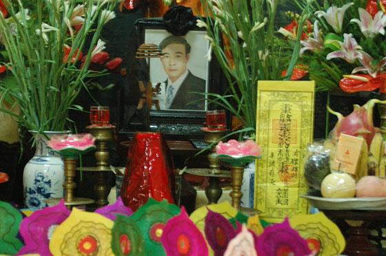 HANOI - Assistiamo ad un rito funebre (o ad una commemorazione) in una pagoda: nella foto l'altare del defunto con offerte, fiori, incenso e preghiere colorate