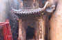 HANOI. Tempio Bach Ma: in un camino d'angolo vengono bruciate offerte votive fatte di carta 
